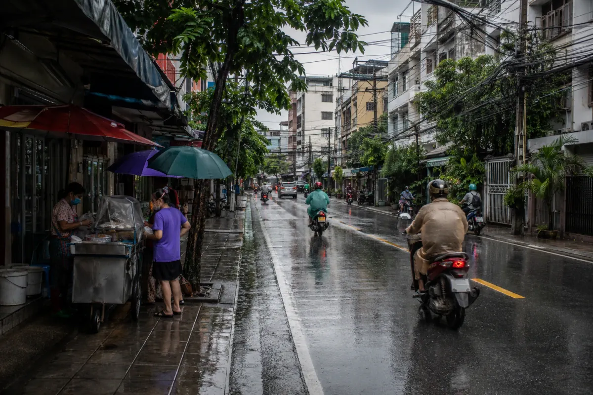 Everyday rainy-season street life on a Bangkok residential side street